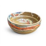 Bol din ceramică rustică lucrat manual cu glazură în nuanțe de portocaliu, albastru și maro, fundal alb.