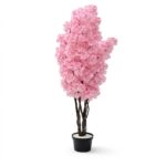 O plantă artificială înaltă, în stil copac de cireș japonez (sakura) în floare, cu o coroană densă de flori roz clustered, plantată într-un ghiveci negru mat cu pietre decorative albe la bază. Fundalul este alb imaculat.