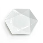 Platou de servire alb din porțelan, formă hexagonală cu design interior geometric, văzut de sus pe fundal alb.