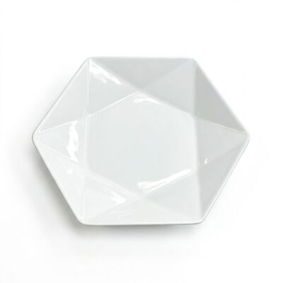 Platou de servire alb din porțelan, formă hexagonală cu design interior geometric, văzut de sus pe fundal alb.
