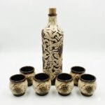 Set tradițional din ceramică format din sticlă și 6 pahare, decorat cu motive în relief cu struguri și viță de vie, pe fundal alb.