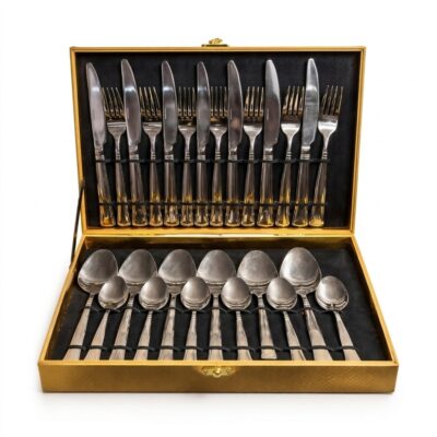 Set complet de tacâmuri premium, așezate într-o cutie aurie elegantă.