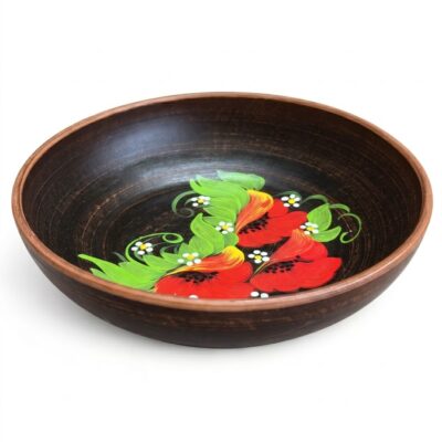 Strachină tradițională românească din lut ars, de culoare închisă, pictată manual la interior cu motive florale specifice: maci roșii, frunze verzi și margarete mici, pe fundal alb curat.
