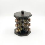 Suport rotativ pentru condimente, realizat din lemn de culoare închisă, echipat cu borcane din sticlă. Prezentare de produs pe fundal alb.