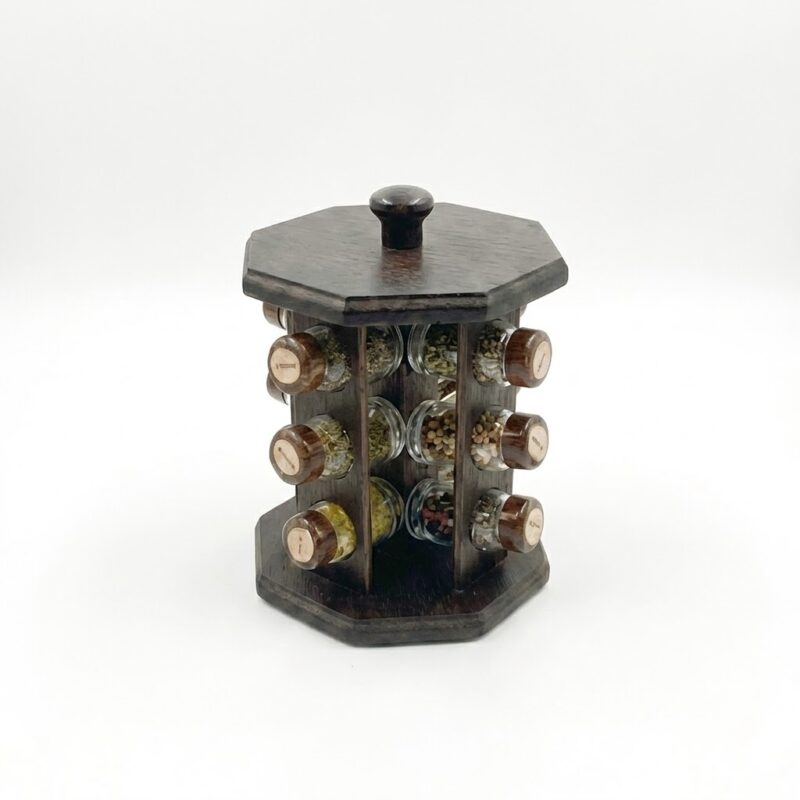 Suport rotativ pentru condimente, realizat din lemn de culoare închisă, echipat cu borcane din sticlă. Prezentare de produs pe fundal alb.
