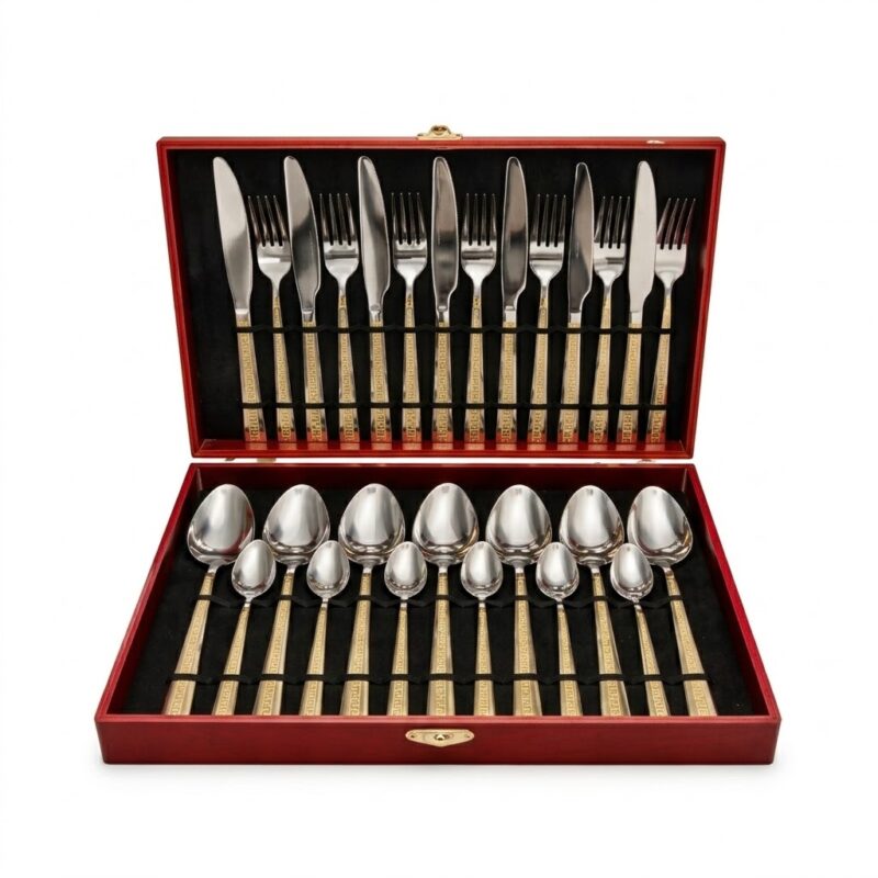 Un set complet de 24 de tacâmuri din oțel inoxidabil cu mânere aurii decorate cu un model geometric, prezentate într-o casetă elegantă din lemn roșu cu interior de catifea neagră
