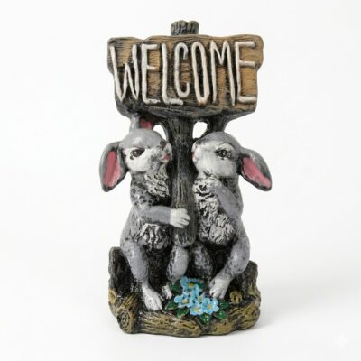 Figurină decorativă din rășină cu doi iepurași care țin o pancartă cu mesajul Welcome, prezentată pe fundal alb.